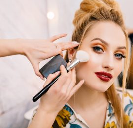 Preparing to party, carnival, celebration of attractive young women in beauty salon. Making makeup, stylish coiffure, professional stylist, cheerful mood, fashionable model